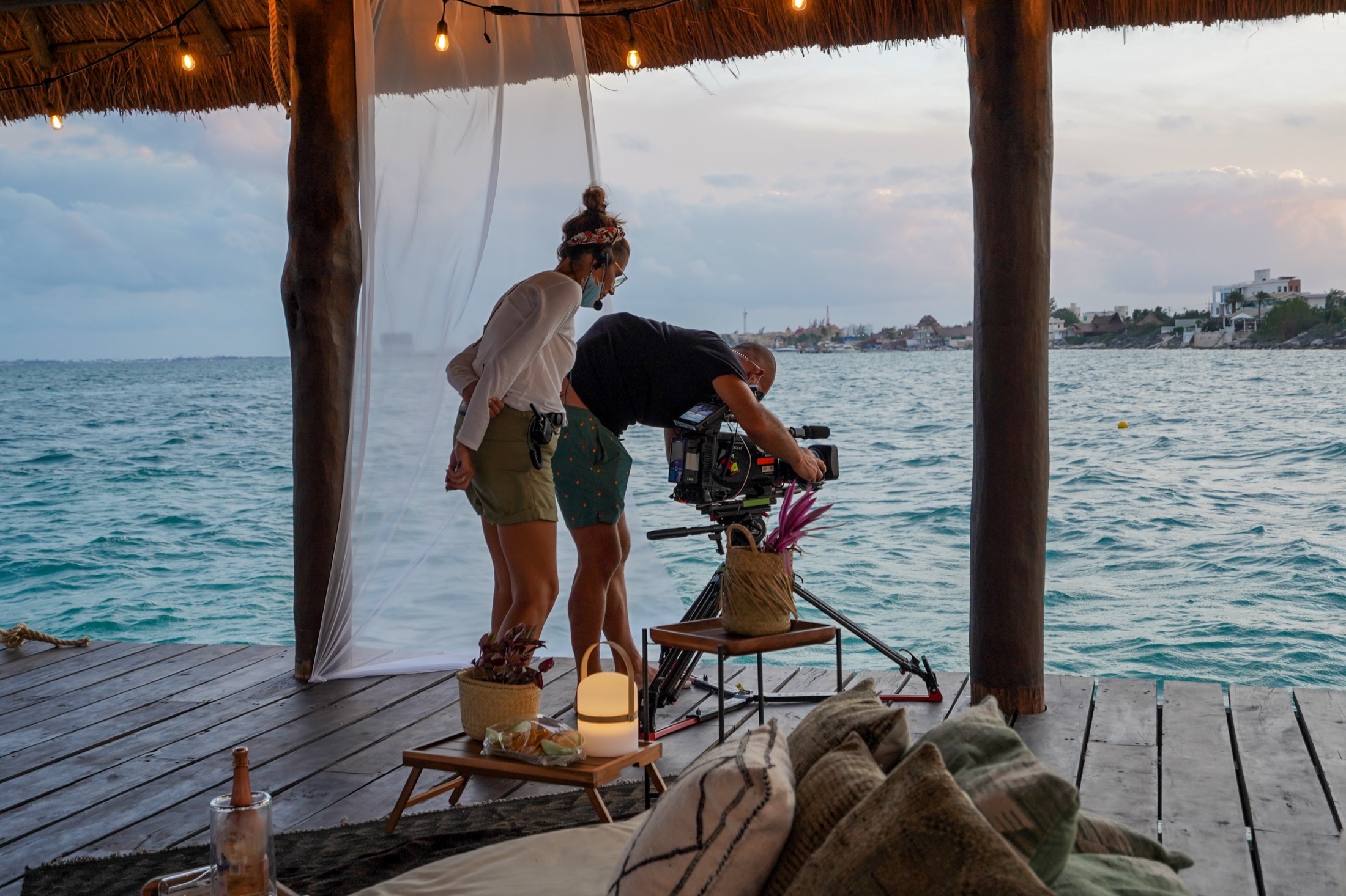 Crew filming at an oceanfront villa at golden hour
